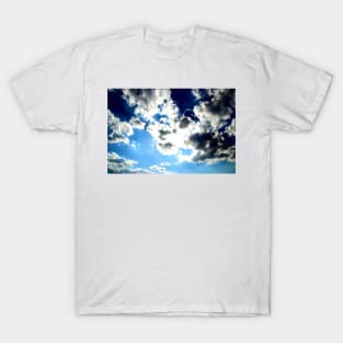 Peaceful scenery with powerful sunbeams making their way through fluffy clouds in the blue sky T-Shirt